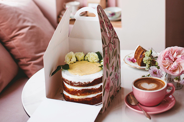 cake in a box with a coffee on the side 